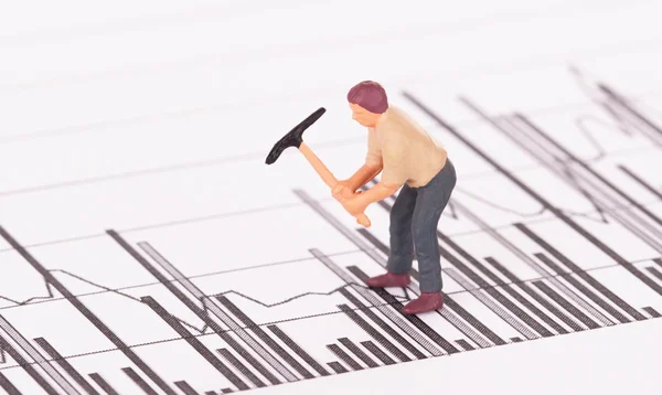 Miniature worker working on a graph — Stock Photo, Image