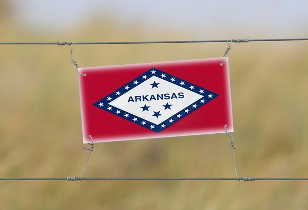 Border fence - Old plastic sign with a flag — Stock Photo, Image