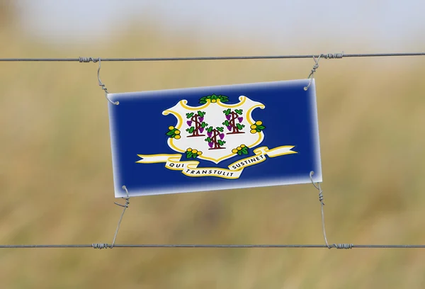 Пограничный забор - старый пластиковый знак с флагом — стоковое фото