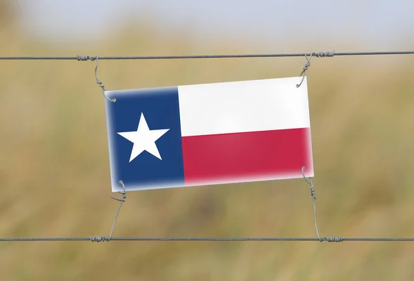 Határ kerítés - régi műanyag jel-val egy zászló — Stock Fotó