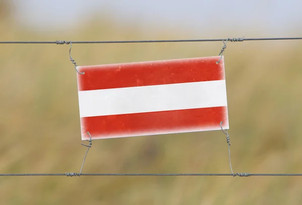 Granicy ogrodzenia - stary znak z tworzywa sztucznego z flagą — Zdjęcie stockowe