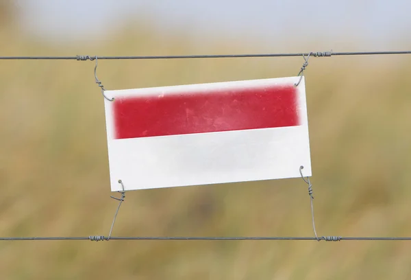 Valla fronteriza - Antiguo letrero de plástico con bandera — Foto de Stock