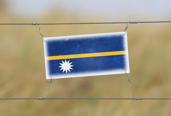 Cerca de fronteira - Plástico antigo com uma bandeira — Fotografia de Stock