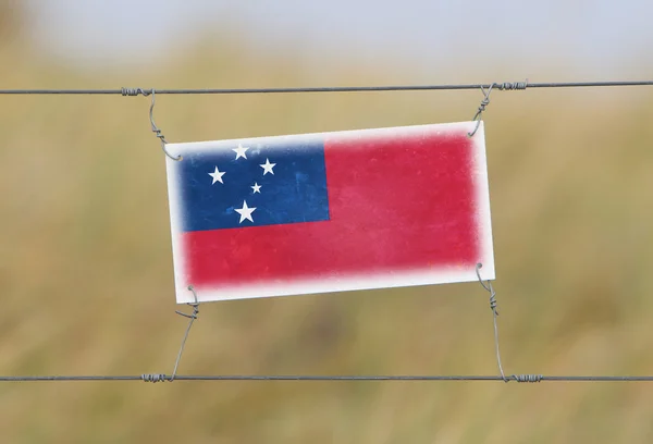 Borderhekje - oude plastic bord met een vlag — Stockfoto