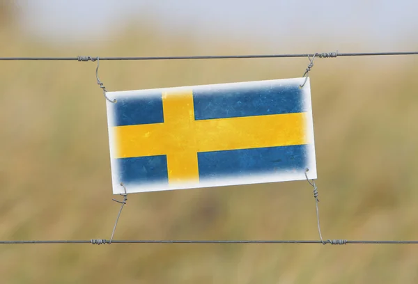 Stängsel - gammal plast tecken med en flagga — Stockfoto