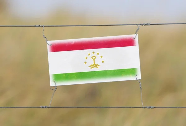 Valla fronteriza - Antiguo letrero de plástico con bandera —  Fotos de Stock