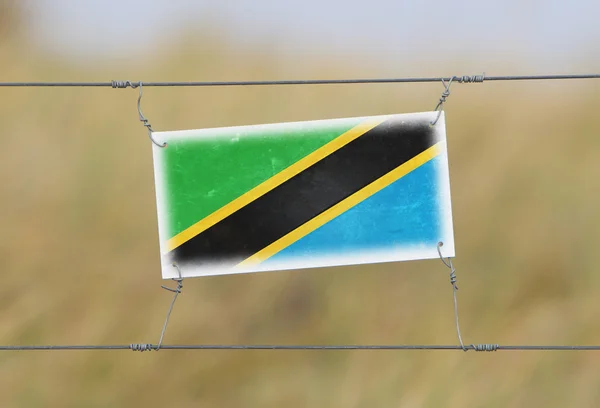 Clôture frontalière - Vieux panneau en plastique avec un drapeau — Photo