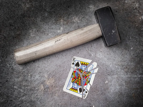 Marteau avec une carte cassée, roi des pique — Photo