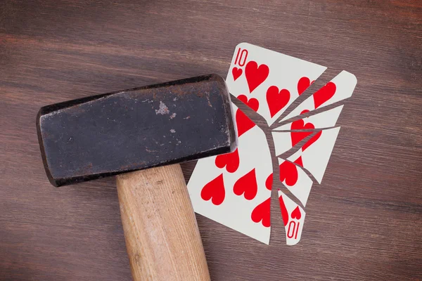 Marteau avec une carte cassée, dix de cœur — Photo
