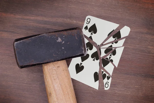 Hammer with a broken card, nine of spades — Stock Photo, Image