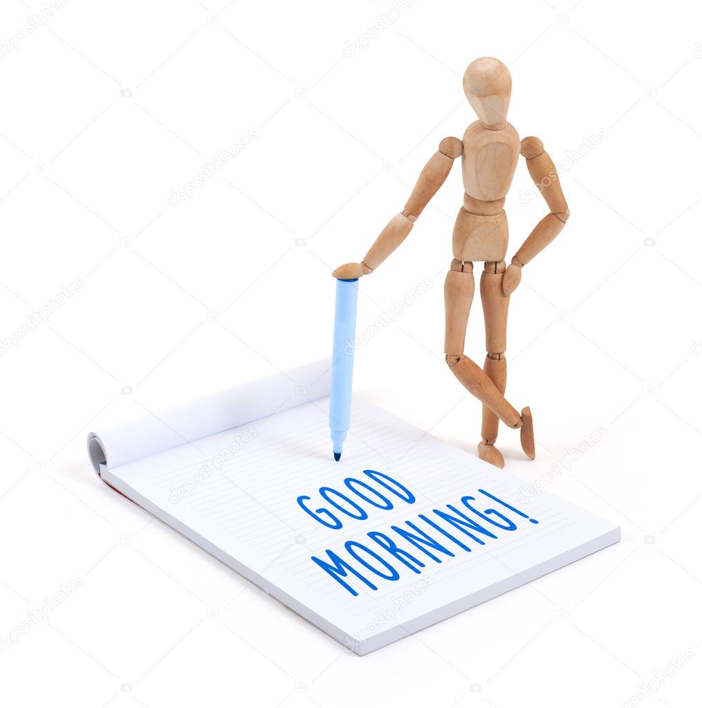 Wooden mannequin writing in scrapbook - Good morning