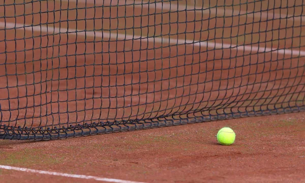 Pelota de tenis en el tenniscourt naranja — Foto de Stock