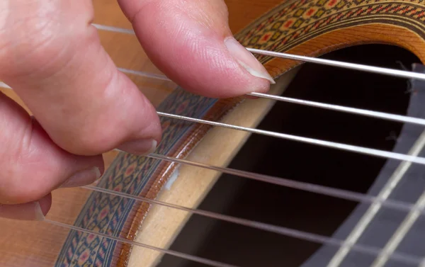 Old woman's hand playing guitar — Stock Photo, Image