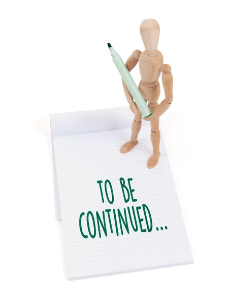 Wooden mannequin writing - To be continued — Stock Image Wooden mannequin writing - To be continued Stock Photo