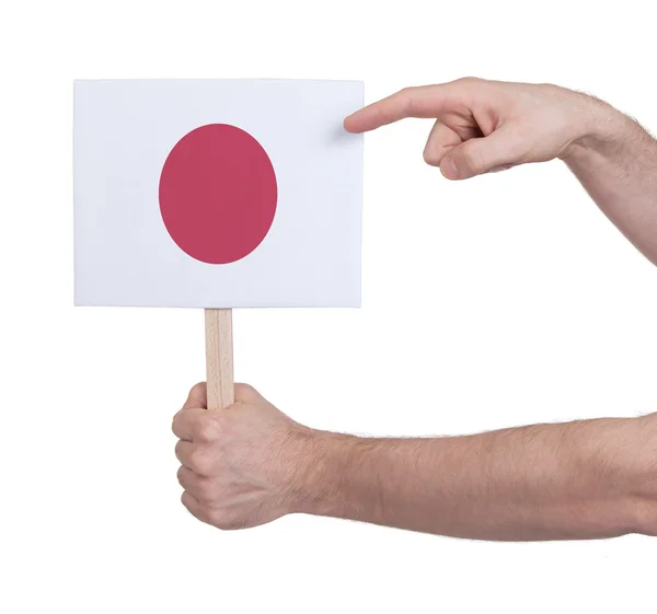 Mano sosteniendo una tarjeta pequeña - Bandera de Japón — Foto de Stock
