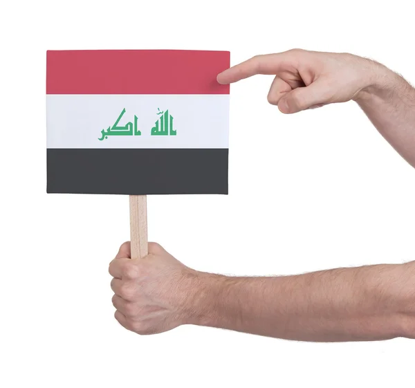 Mano sosteniendo una tarjeta pequeña - Bandera de Irak — Foto de Stock