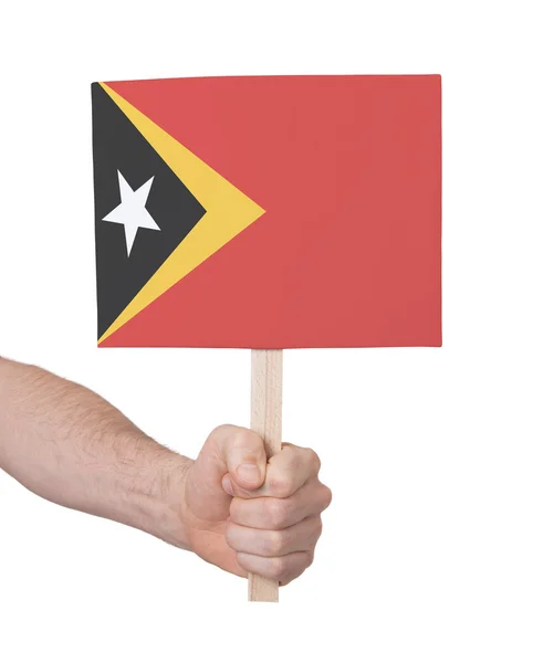 Hand met kleine kaartje - vlag van Oost-Timor — Stockfoto