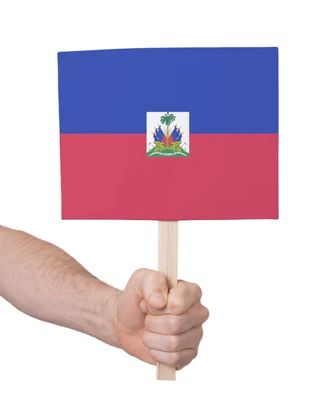 Hand met kleine kaartje - vlag van Haïti — Stockfoto