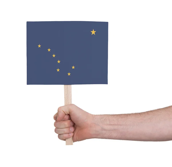 Hand holding small card - Flag of Alaska — Stock Photo, Image