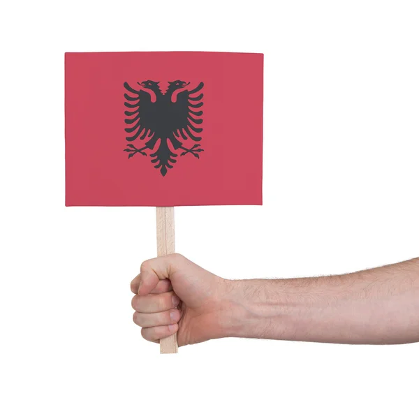 Hand met kleine kaartje - vlag van Albanië — Stockfoto