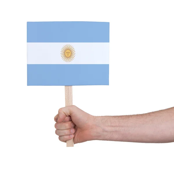 Mão segurando cartão pequeno - Bandeira da Argentina — Fotografia de Stock