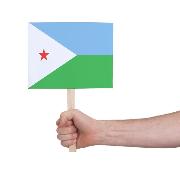 Mão segurando cartão pequeno - Bandeira de Djibouti — Fotografia de Stock