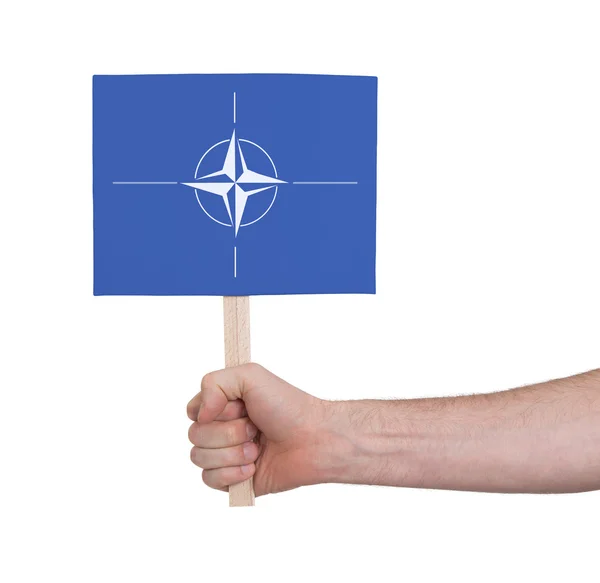 Hand holding small card - Flag of NATO — Stock Photo, Image