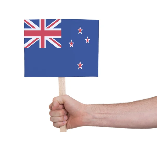Mano sosteniendo una tarjeta pequeña - Bandera de Nueva Zelanda — Foto de Stock