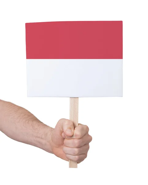 Mão segurando cartão pequeno - Bandeira de Mônaco — Fotografia de Stock