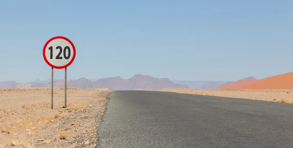 Señal de límite de velocidad en una carretera desierta en Namibia —  Fotos de Stock