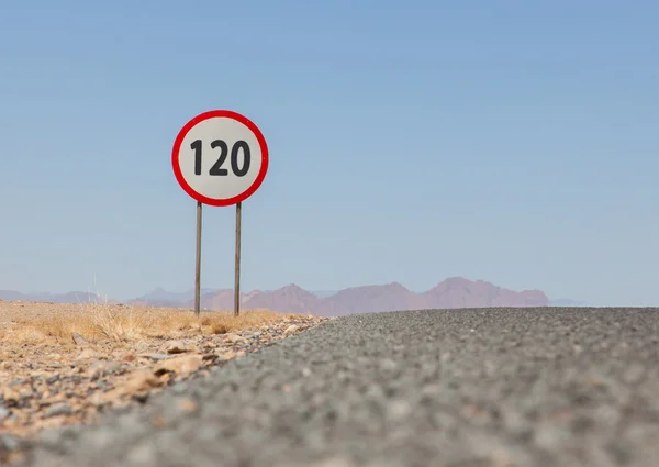 Señal de límite de velocidad en una carretera desierta en Namibia —  Fotos de Stock