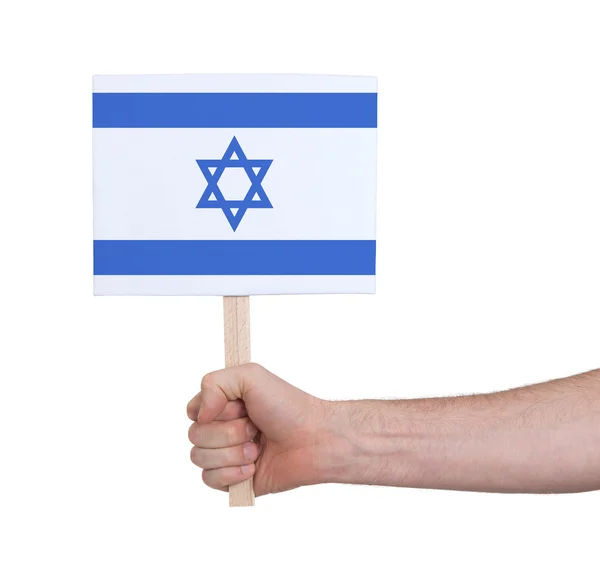 Mano sosteniendo una tarjeta pequeña - Bandera de Israel —  Fotos de Stock