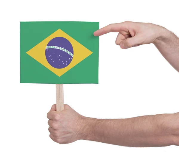 Mão segurando cartão pequeno - Bandeira do Brasil — Fotografia de Stock