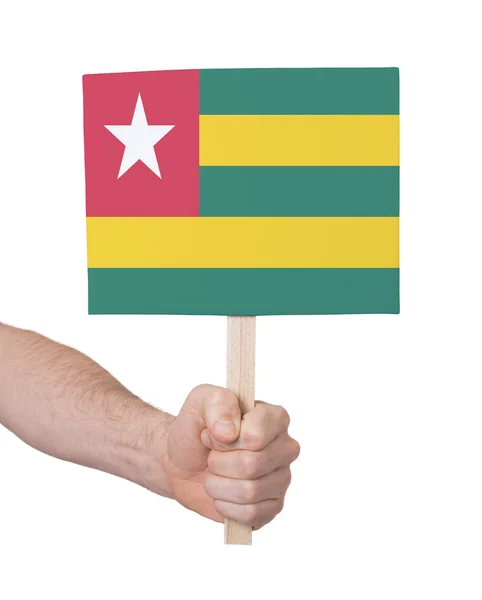 Mão segurando cartão pequeno - Bandeira do Togo — Fotografia de Stock
