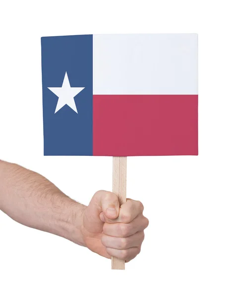 Mano sosteniendo una tarjeta pequeña - Bandera de Texas —  Fotos de Stock