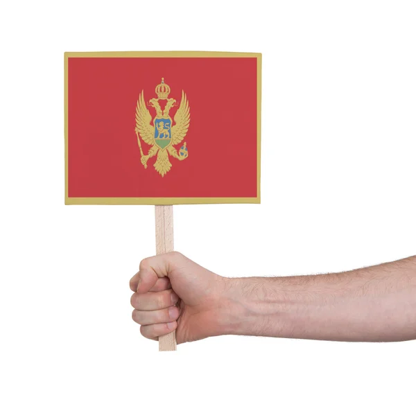 Hand som håller litet kort - flagga i Montenegro — Stockfoto