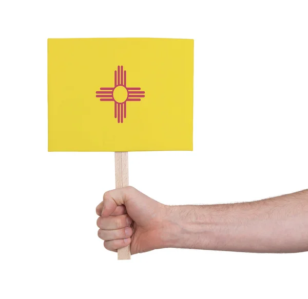 Mano sosteniendo una tarjeta pequeña - Bandera de Nuevo México — Foto de Stock