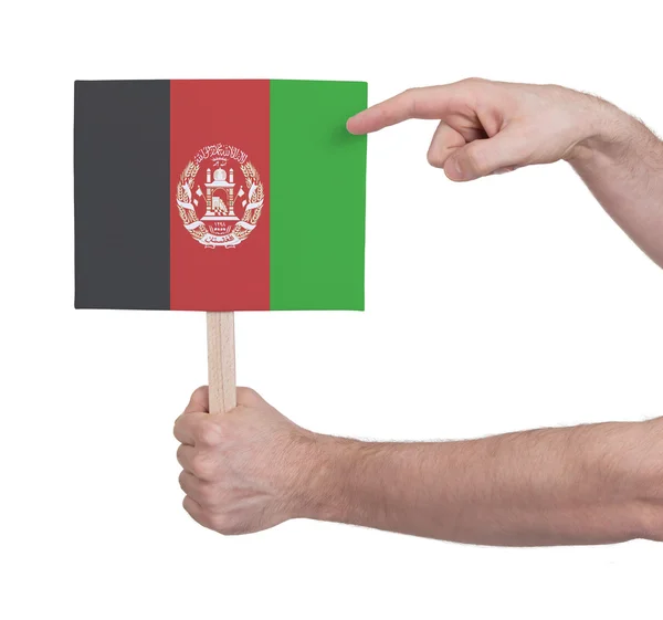 Руки, що тримає невелика картка - прапор Афганістану — стокове фото