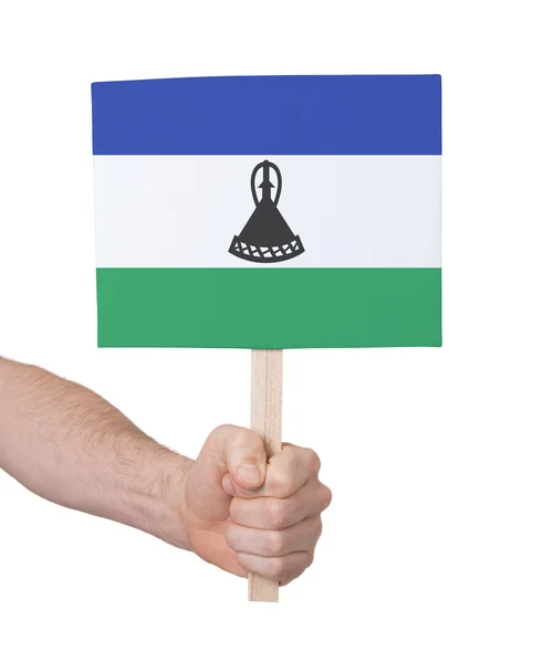 Hand met kleine kaartje - vlag van Lesotho — Stockfoto