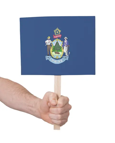 Mão segurando cartão pequeno - Bandeira do Maine — Fotografia de Stock