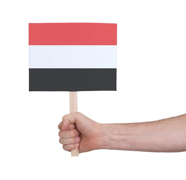 Mano sosteniendo una tarjeta pequeña - Bandera de Yemen — Foto de Stock