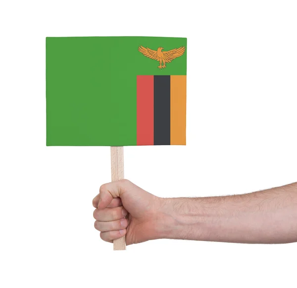 Hand hält kleine Karte - Flagge von Sambia — Stockfoto
