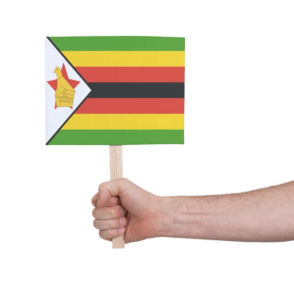 Hand hält kleine Karte - Fahne von Zimbabwe — Stockfoto
