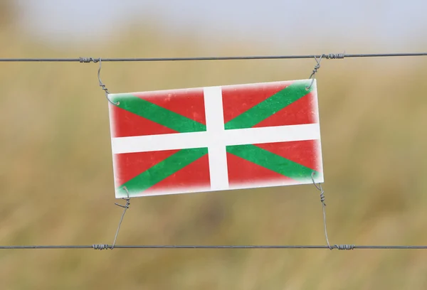 Cerca de fronteira - Plástico antigo com uma bandeira — Fotografia de Stock