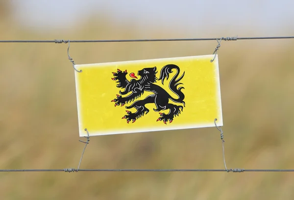 Granicy ogrodzenia - stary znak z tworzywa sztucznego z flagą — Zdjęcie stockowe
