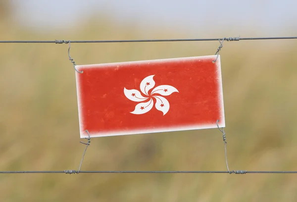 Határ kerítés - régi műanyag jel-val egy zászló — Stock Fotó
