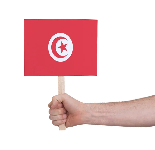 Mão segurando cartão pequeno - Bandeira da Tunísia — Fotografia de Stock