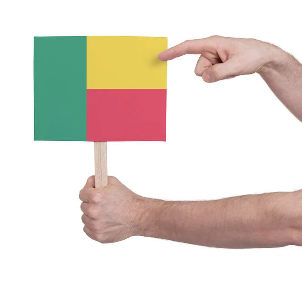 Mão segurando cartão pequeno - Bandeira do Benim — Fotografia de Stock