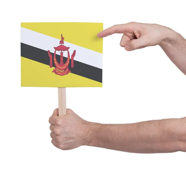 Hand met kleine kaartje - vlag van Brunei — Stockfoto