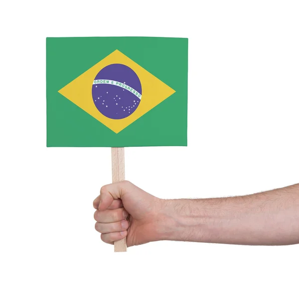 Mão segurando cartão pequeno - Bandeira do Brasil — Fotografia de Stock